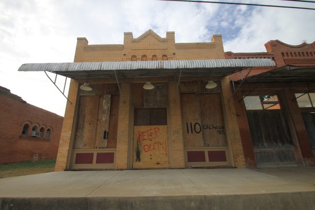 Old storefronts with a parapet in Rice, photographed in 2014